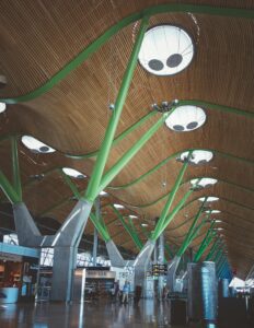 Capture of Madrid Airport's modern architectural interior with wooden ceiling and green supports.